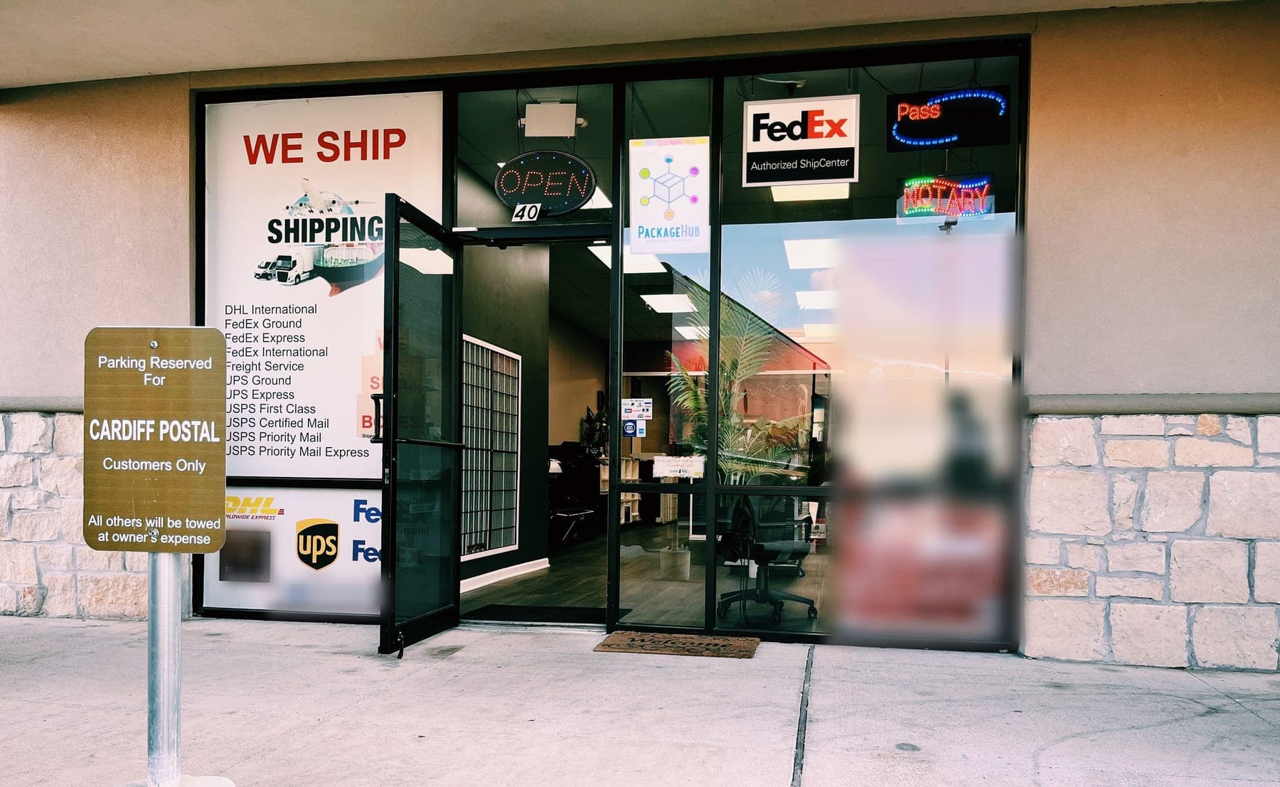 The Cardiff Postal entrance, Suite 40, with a We Ship window poster listing carriers, a FedEx Authorized ShipCenter sign, a Notary sign and a Parking Reserved for Cardiff Postal Customers sign