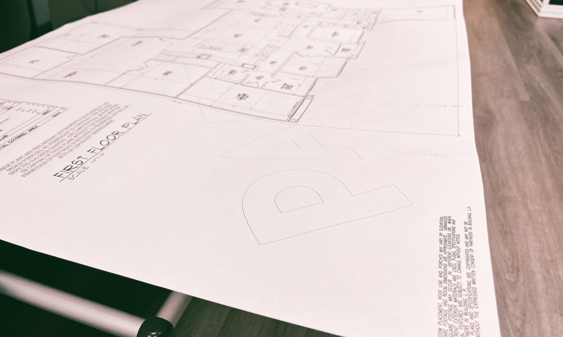 A large architectural floor plan print laid out on a table