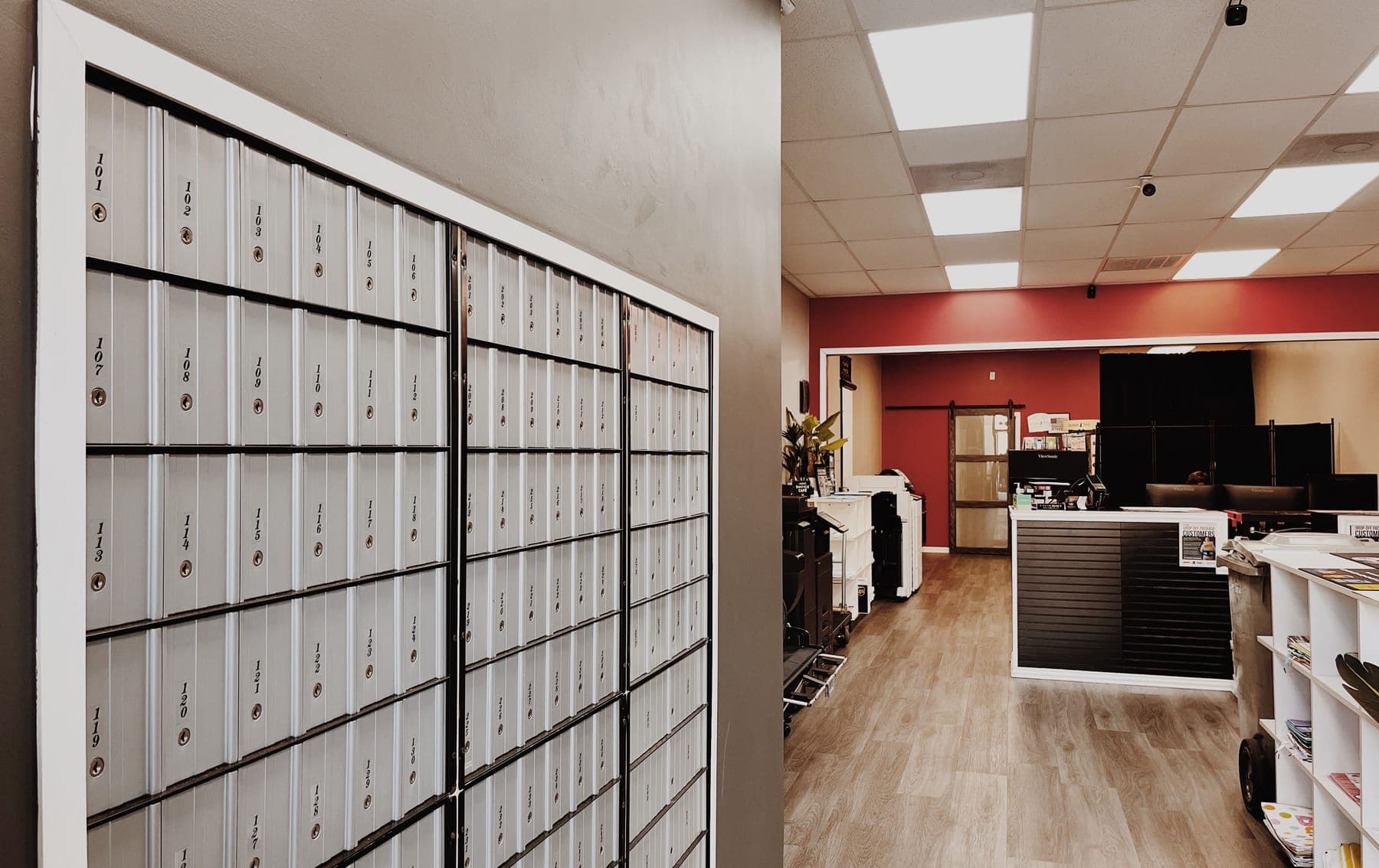Private mailboxes near the entrance with the service counter and red accent wall beyond