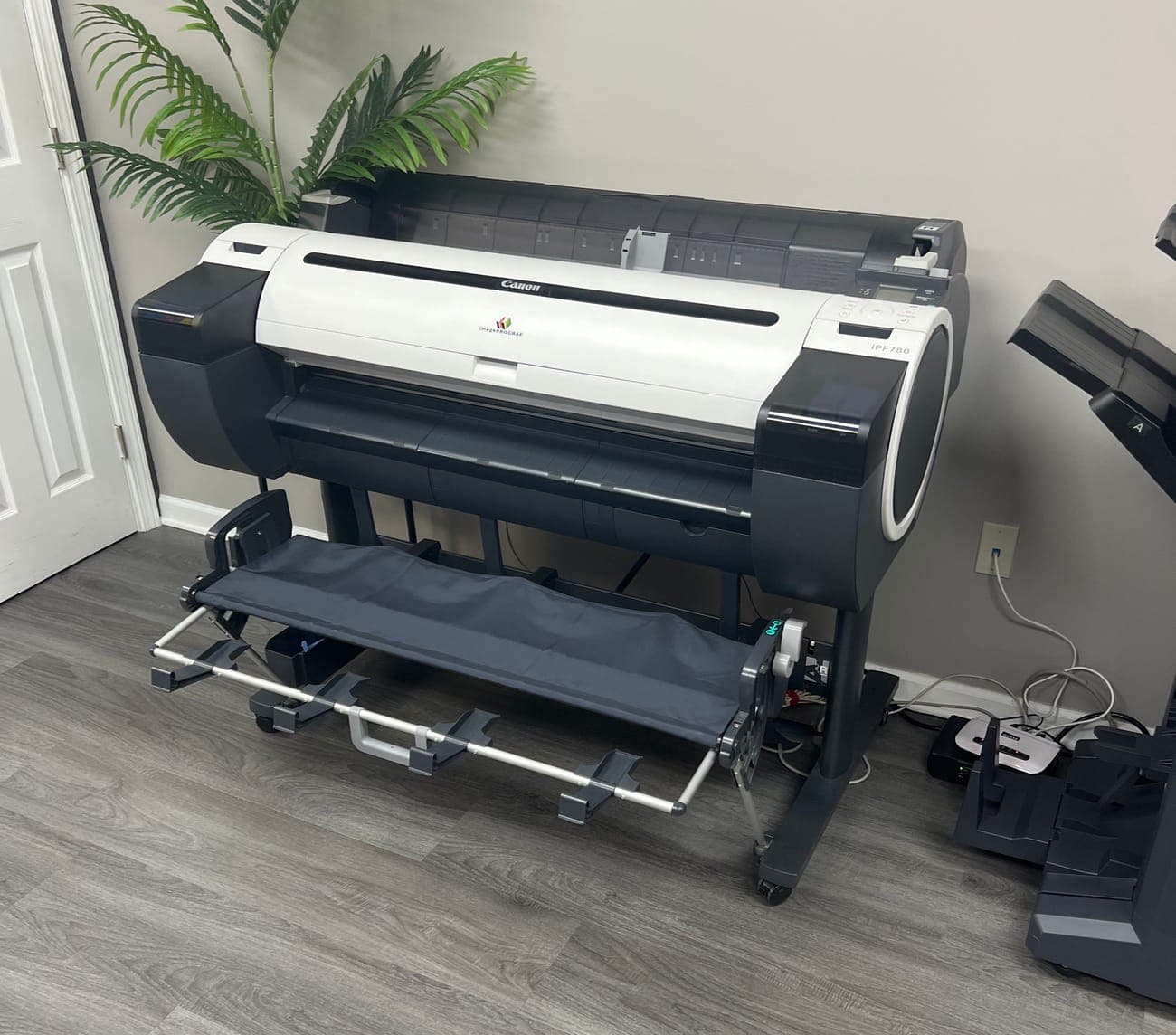 A wide-format printer on a stand inside the store